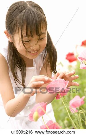 Stock Photograph - Photography of a girl in the flower garden, Low Angle View. Fotosearch