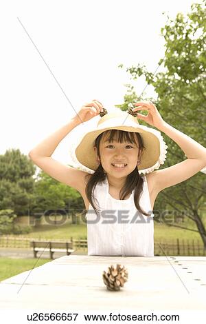 Photography of a girl playing with pine cones, Front View View Large Photo Image Stock Photo - Photography of a girl playing with pine cones, Front View. Fotosearch