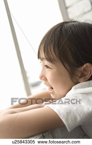 Stock Photography - Photography of a girl smiling and looking away, Low Angle View. Fotosearch