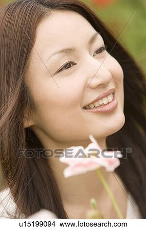 Photography of a mid adult woman with flower, Differential Focus View Large Photo Image Picture - Photography of a mid adult woman with flower, Differential Focus. Fotosearch