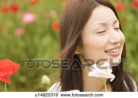 Stock Photo - Photography of a mid adult woman with flower, Differential Focus. Fotosearch