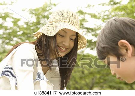 Stock Photo - Photography of a mother and son playing in the park, Low Angle View. Fotosearch