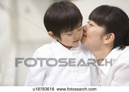 Stock Photo - Photography of a mother kissing boy, Differential Focus. Fotosearch