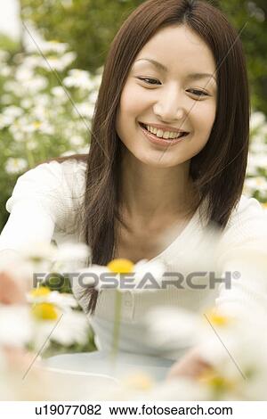 Stock Image - Photography of a woman surrounded by flowers, High Angle View. Fotosearch