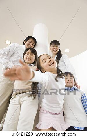 Stock Image - Photography of parents and children smiling at camera, Low Angle View. Fotosearch