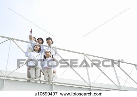 Stock Photo - Photography of parents and children looking up to the sky, Low Angle View. Fotosearch
