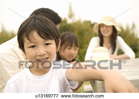 Stock Photo - Photography of parents and children relaxing on the table in the park, Differential Focus. Fotosearch
