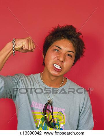 Portrait of Young Man Making a Face, Clenching His Fist, Front View View Large Photo Image Stock Image - Portrait of Young Man Making a Face, Clenching His Fist, Front View . Fotosearch
