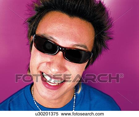 Stock Photography - Portrait of Young Man Smiling, Wearing Sunglasses, Front View . Fotosearch