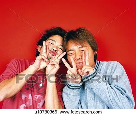Stock Photograph - Portrait of Young Men Making Peace Signs, Front View. Fotosearch