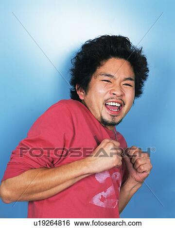 Stock Photograph - Portrait of Young Smiling, Clenching His Fist, Front View . Fotosearch