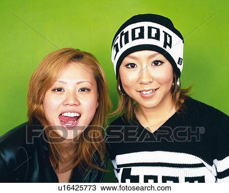 Stock Image - Young Women Smiling, Portrait, One Woman Sticking Out Tongue, Front View . Fotosearch