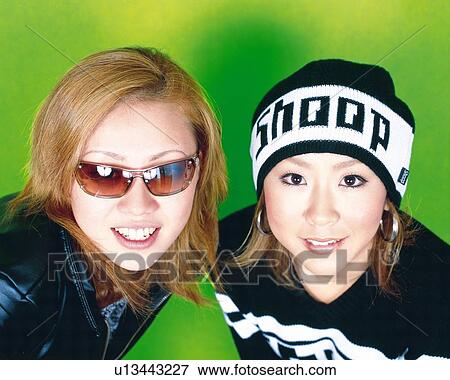 Stock Photo - Young Women Smiling, Portrait, One Woman Wearing Sunglasses, High Angle View . Fotosearch