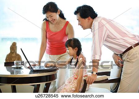 Stock Photography - A girl learning on laptop from her parents.. Fotosearch