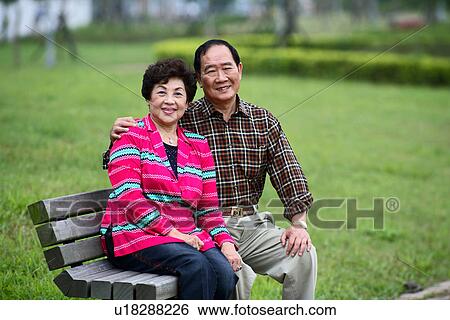 Stock Photograph - Portrait of senior couple sitting on bench.. Fotosearch