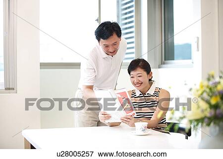 View of a couple reading a magazine. View Large Photo Image Stock Photo - View of a couple reading a magazine.. Fotosearch