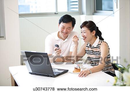 View of a couple sitting and watching laptop. View Large Photo Image Stock Photo - View of a couple sitting and watching laptop.. Fotosearch