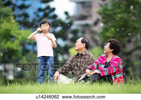 View of a couple sitting in a garden. View Large Photo Image Stock Image - View of a couple sitting in a garden.. Fotosearch