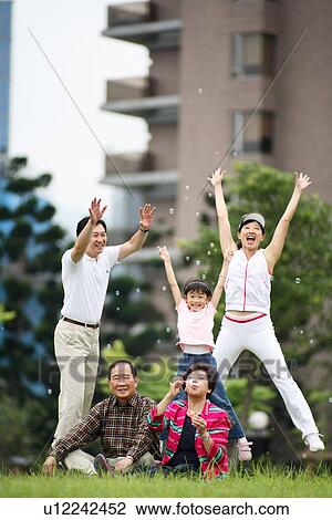 Stock Image - View of a family enjoying in a park.. Fotosearch