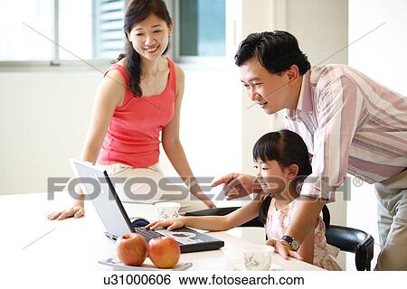 Stock Photograph - View of a family looking at laptop.. Fotosearch