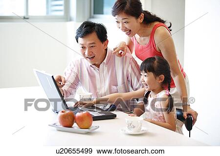 View of a family sitting and watching laptop. View Large Photo Image Stock Photo - View of a family sitting and watching laptop.. Fotosearch