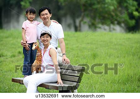 View of a family sitting on the bench. View Large Photo Image Stock Image - View of a family sitting on the bench.. Fotosearch