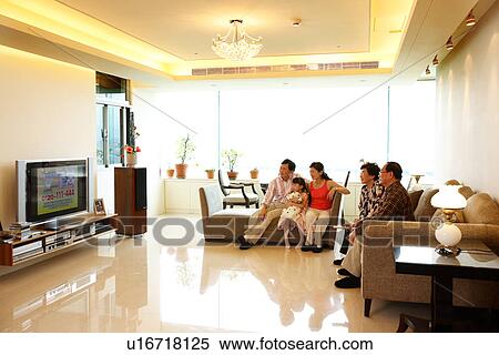 Stock Photography - View of a family watching television.. Fotosearch