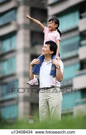 Picture - View of a father carrying her daughter.. Fotosearch