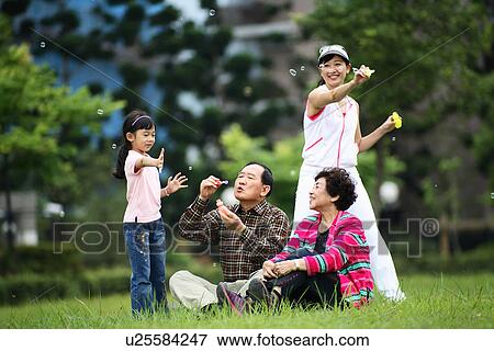 View of a girl enjoying with her family. View Large Photo Image Stock Photo - View of a girl enjoying with her family.. Fotosearch