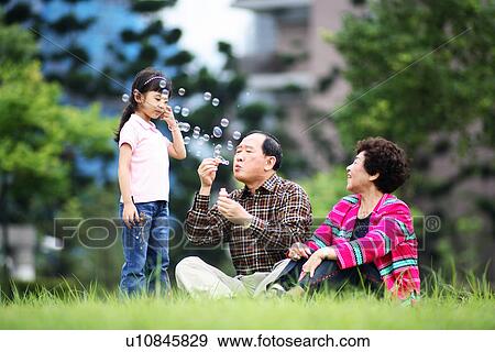 Stock Photo - View of a girl enjoying with her grandparents.. Fotosearch
