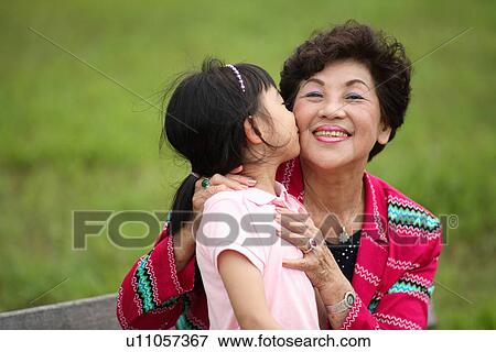 View of a girl kissing her grandmother. View Large Photo Image Stock Photo - View of a girl kissing her grandmother.. Fotosearch