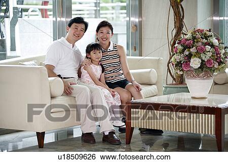 Stock Photograph - View of a girl sitting with her parent.. Fotosearch