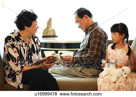 Stock Photo - View of a girl sitting with her grandparent.. Fotosearch