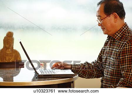 Stock Image - View of a man using laptop.. Fotosearch
