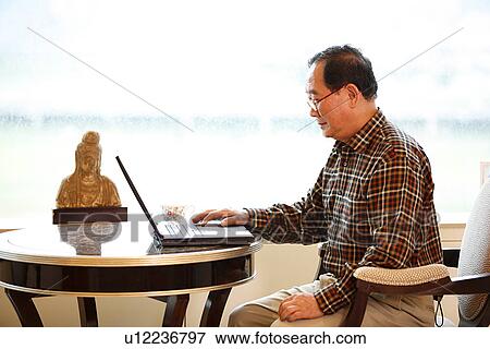 Stock Photo - View of a man using laptop.. Fotosearch