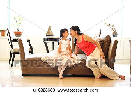 Stock Photo - View of a woman kissing her daughter.. Fotosearch