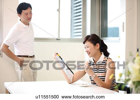 Stock Image - View of a woman reading magazine.. Fotosearch