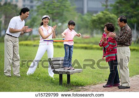 Stock Photo - View of parents encouraging their daughter.. Fotosearch