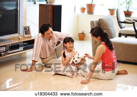 Stock Image - View of parents playing with their child.. Fotosearch