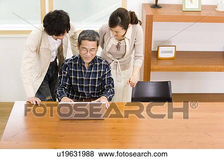 A Family Enjoying with a Laptop Computer, High Angle View View Large Photo Image Stock Photo - A Family Enjoying with a Laptop Computer, High Angle View. Fotosearch