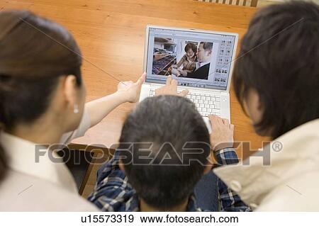 A Family Looking at a Computer Monitor Together, Rear View, High Angle View, Differential Focus View Large Photo Image Stock Photo - A Family Looking at a Computer Monitor Together, Rear View, High Angle View, Differential Focus. Fotosearch
