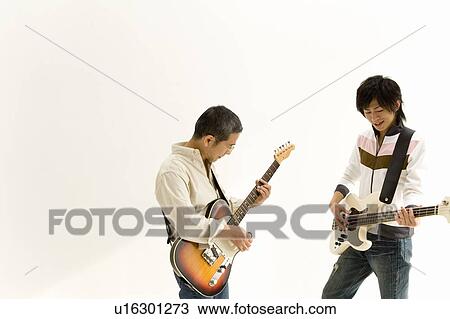 Stock Image - A Father and His Son Playing Guitars Together, Side View, Copy Space. Fotosearch