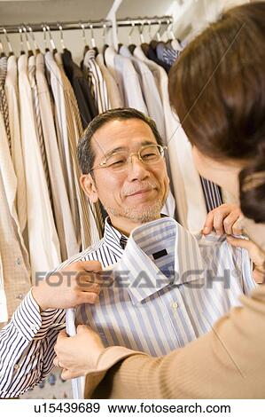 Stock Photo - A Mature Adult Couple Choosing Clothes at a Clothes Shop, Front View, Rear View. Fotosearch