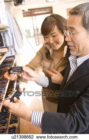 Stock Image - A Mature Adult Couple Shopping, Side View, Differential Focus. Fotosearch