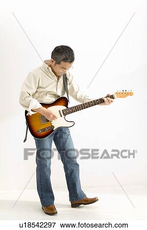 Stock Photo - A Mature Adult Man Playing a Guitar, Front View, Side View. Fotosearch