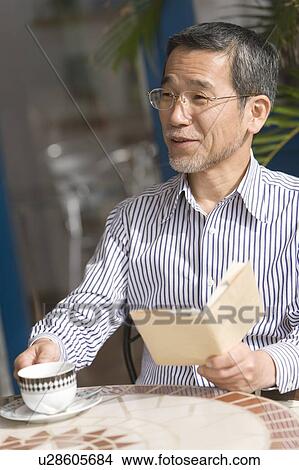 A Mature Adult Man Relaxing at a Cafe, Front View, Side View, Differential Focus View Large Photo Image Picture - A Mature Adult Man Relaxing at a Cafe, Front View, Side View, Differential Focus. Fotosearch