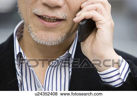 A Mature Adult Man Talking on a Mobile Phone, Front View, Close Up, Differential Focus View Large Photo Image Stock Photo - A Mature Adult Man Talking on a Mobile Phone, Front View, Close Up, Differential Focus. Fotosearch