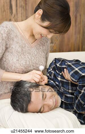 Picture - A Mature Adult Woman Cleaning Her Husband's Ear, Front View, Side View. Fotosearch