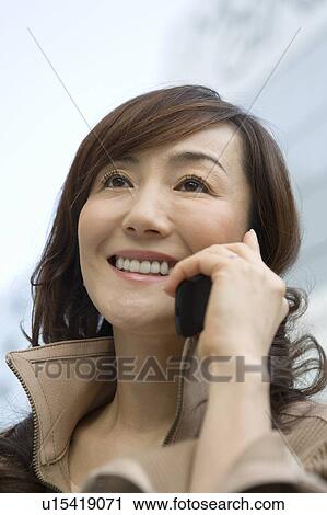 A Mature Adult Woman Talking on a Mobile Phone, Low Angle View, Differential Focus, Close Up View Large Photo Image Stock Image - A Mature Adult Woman Talking on a Mobile Phone, Low Angle View, Differential Focus, Close Up. Fotosearch