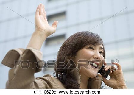 A Mature Adult Woman Talking on a Mobile Phone and Waving Her Hand, Low Angle View, Side View, Differential Focus View Large Photo Image Stock Photography - A Mature Adult Woman Talking on a Mobile Phone and Waving Her Hand, Low Angle View, Side View, Differential Focus. Fotosearch